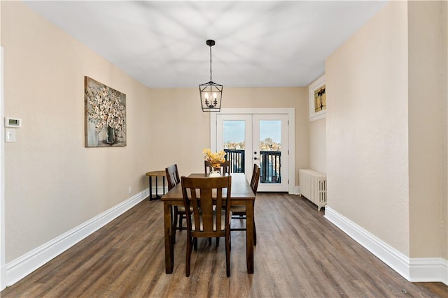 dining room with a notable chandelier, dark hardwood / wood-style flooring, radiator heating unit, and french doors