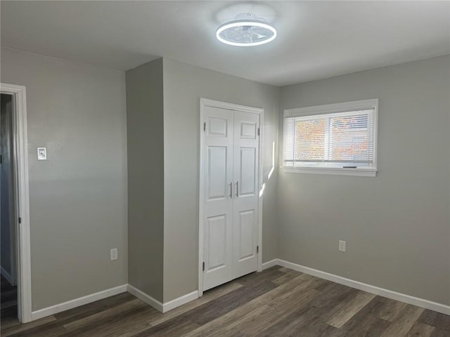 unfurnished bedroom with a closet and dark hardwood / wood-style flooring