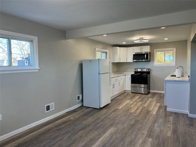 kitchen with white cabinets, dark hardwood / wood-style floors, sink, and appliances with stainless steel finishes