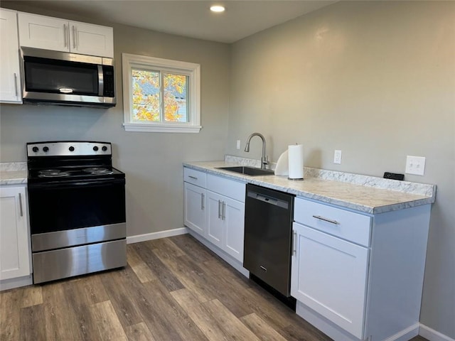 kitchen with dark hardwood / wood-style flooring, sink, white cabinets, and appliances with stainless steel finishes