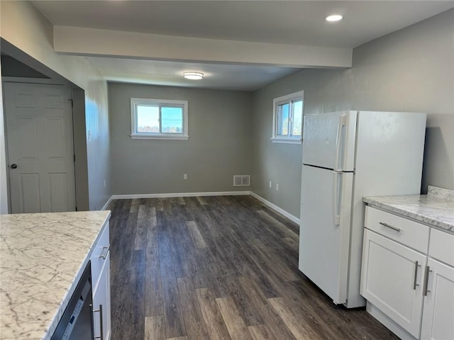 kitchen with white cabinets, white refrigerator, dark hardwood / wood-style flooring, and light stone counters