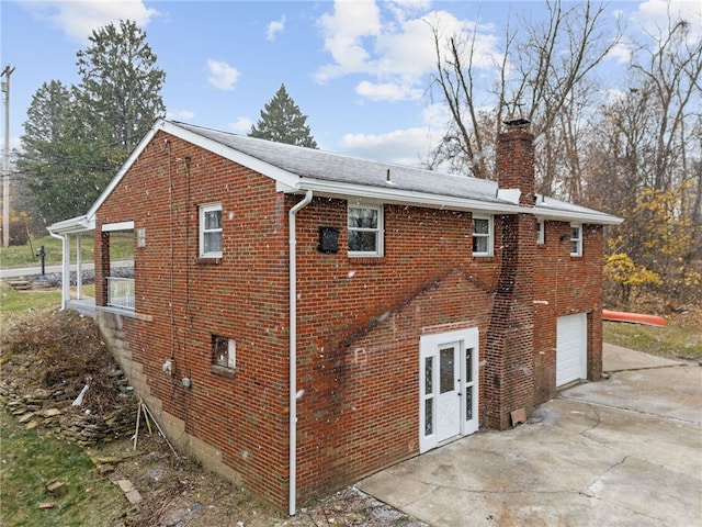 727 Scenery Dr, Elizabeth Twp/Boro, PA 15037 - back of house with brick siding, concrete driveway, a garage, and a chimney