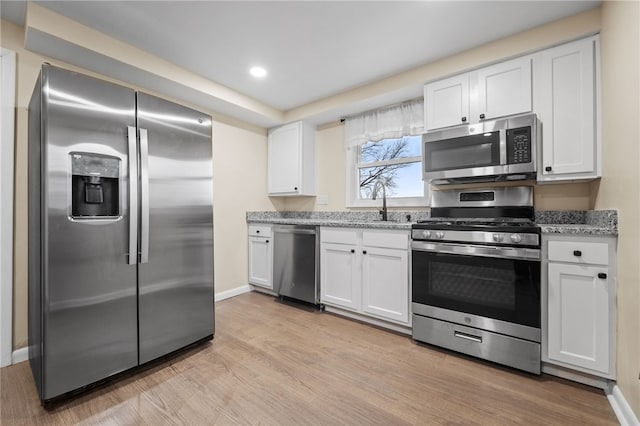 727 Scenery Dr, Elizabeth Twp/Boro, PA 15037 - kitchen featuring stainless steel appliances, light wood-style flooring, white cabinetry, light stone countertops, and recessed lighting