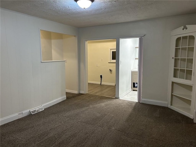 carpeted empty room featuring a textured ceiling