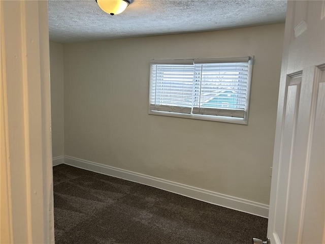 carpeted empty room with a textured ceiling