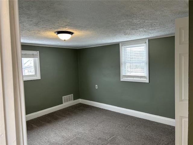 carpeted empty room with a textured ceiling