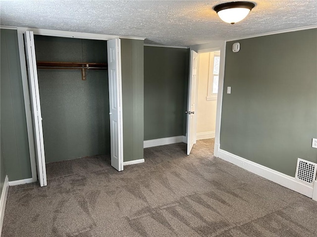 unfurnished bedroom with a closet, carpet, and a textured ceiling