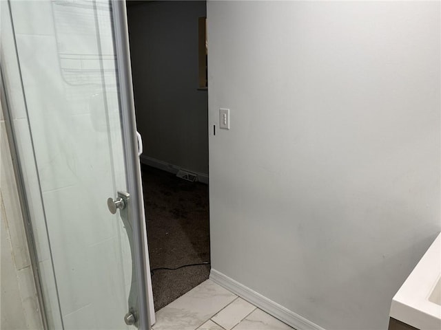 bathroom with vanity and a shower with door