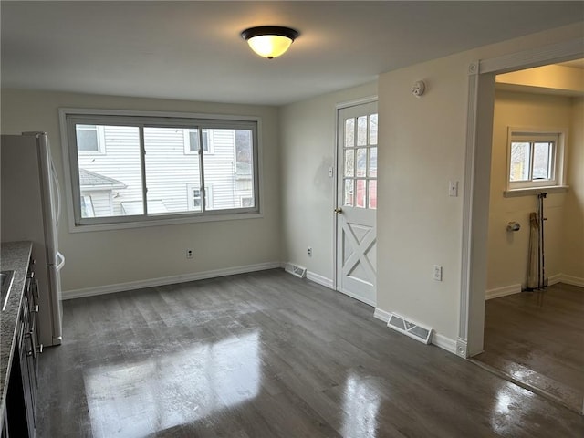 unfurnished dining area featuring dark hardwood / wood-style floors