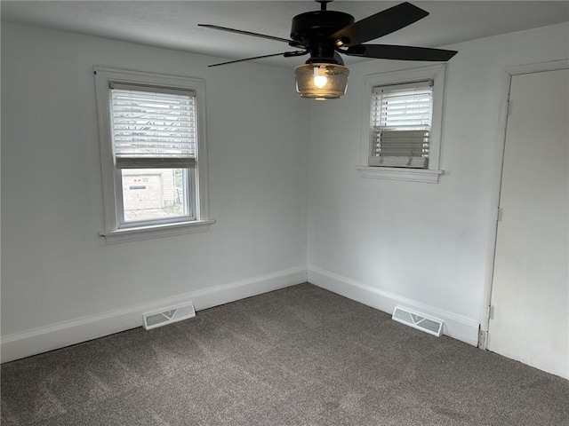 carpeted empty room featuring a wealth of natural light and ceiling fan