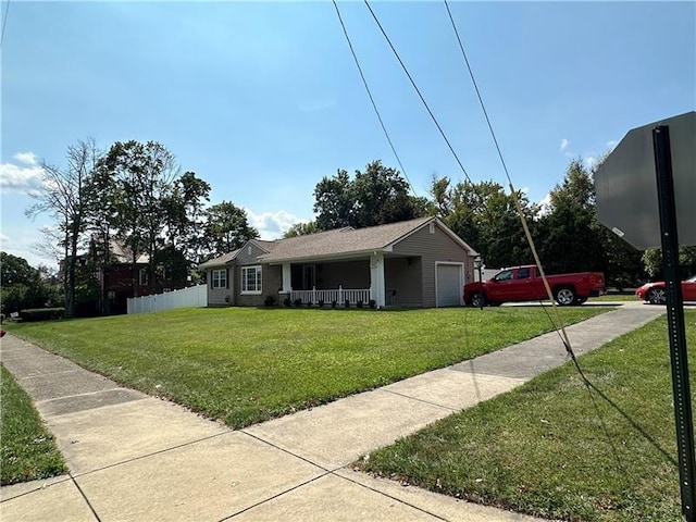 view of front of property featuring a front lawn, a porch, and a garage