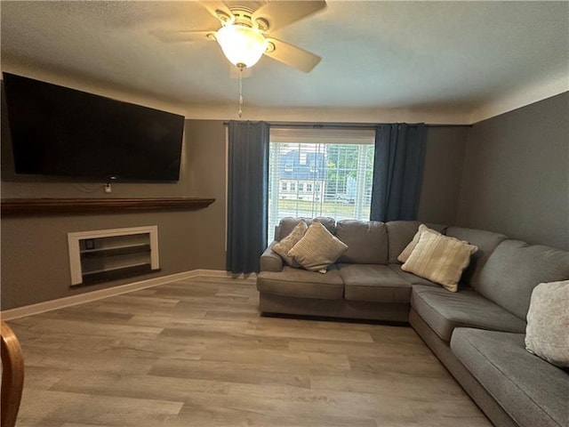 living room with ceiling fan and light hardwood / wood-style flooring