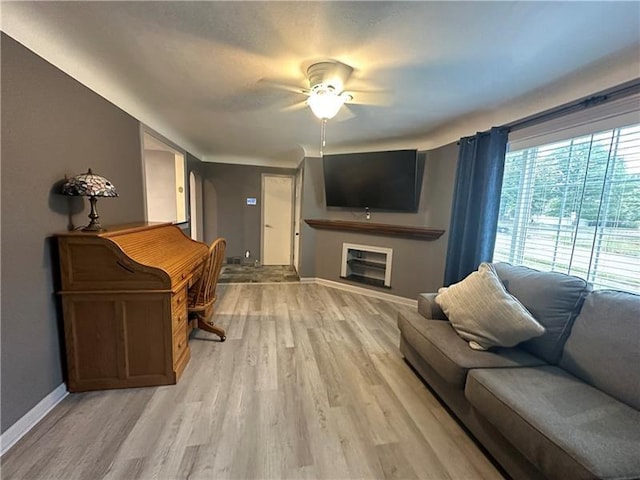 living room with light hardwood / wood-style floors and ceiling fan