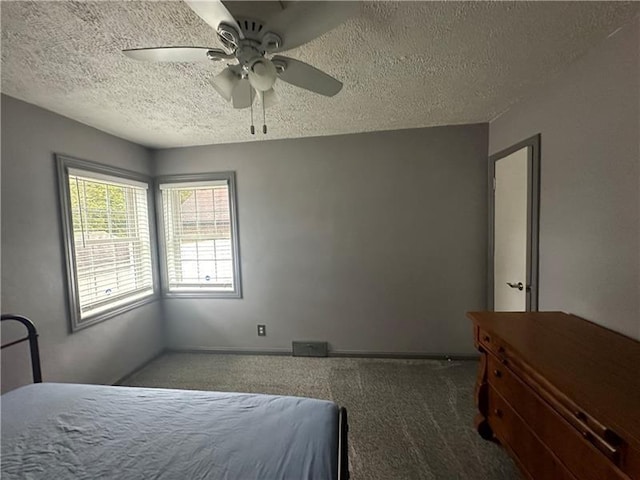 carpeted bedroom with ceiling fan and a textured ceiling