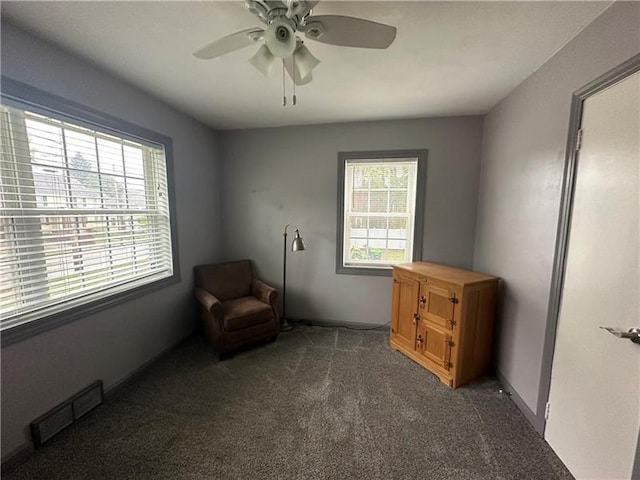 living area with dark colored carpet and ceiling fan