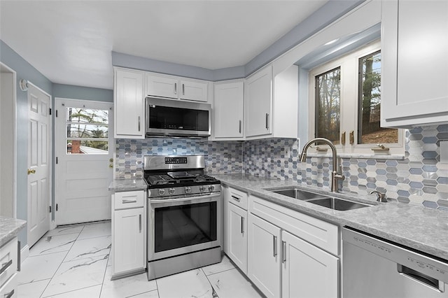 kitchen featuring decorative backsplash, sink, white cabinetry, and stainless steel appliances