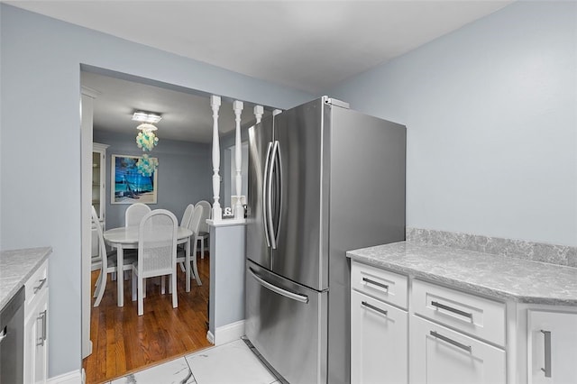 kitchen with white cabinetry, appliances with stainless steel finishes, and light hardwood / wood-style flooring