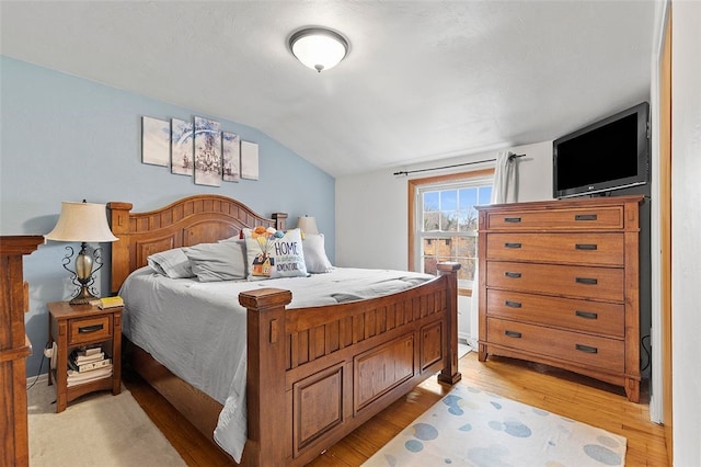 bedroom with light hardwood / wood-style floors and vaulted ceiling