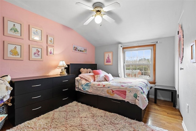 bedroom with light wood-type flooring, vaulted ceiling, and ceiling fan