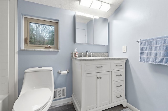 bathroom with vanity, wood-type flooring, a textured ceiling, and toilet