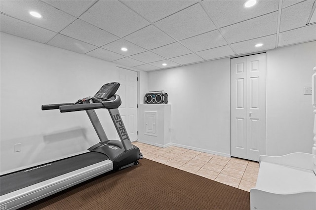 workout area with a drop ceiling and light tile patterned flooring