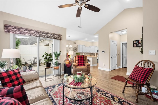 living room featuring ceiling fan with notable chandelier, high vaulted ceiling, and light hardwood / wood-style flooring