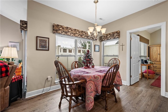 dining room featuring dark hardwood / wood-style flooring and an inviting chandelier