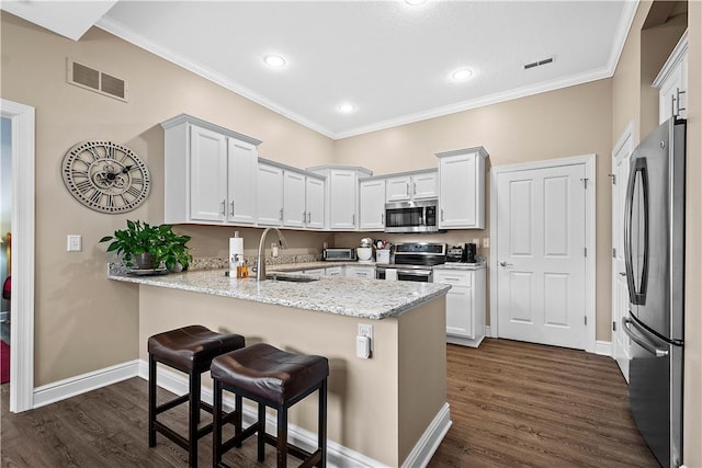 kitchen featuring kitchen peninsula, stainless steel appliances, white cabinetry, and sink