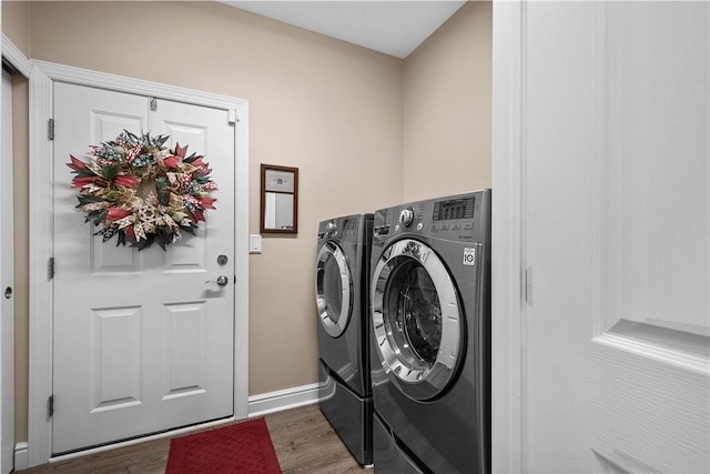 clothes washing area featuring washer and dryer and dark hardwood / wood-style flooring