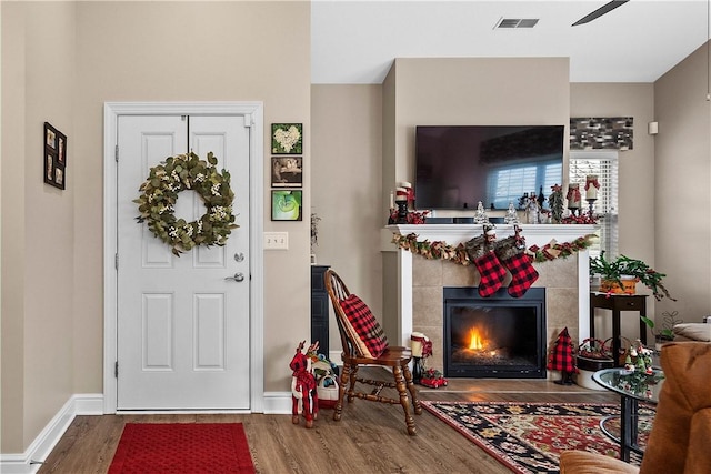 entryway with a tile fireplace, ceiling fan, and hardwood / wood-style flooring