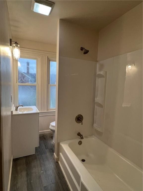 full bathroom with shower / tub combination, vanity, wood-type flooring, and toilet