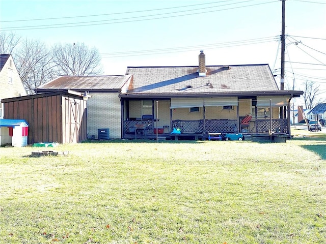 back of house featuring central AC unit and a yard