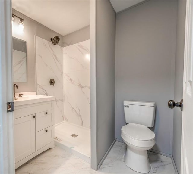 bathroom featuring a tile shower, vanity, and toilet