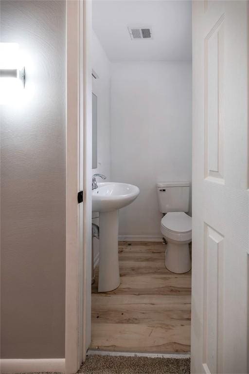 bathroom with sink, wood-type flooring, and toilet