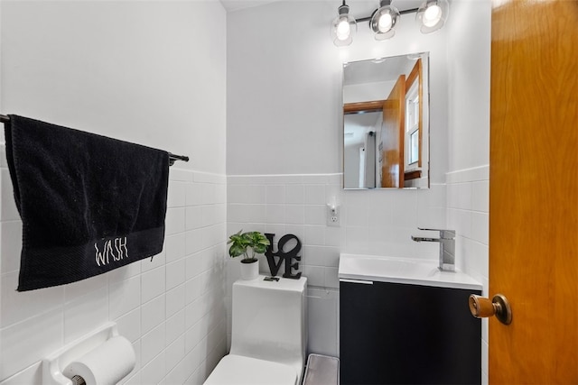 bathroom with vanity, tile walls, and toilet