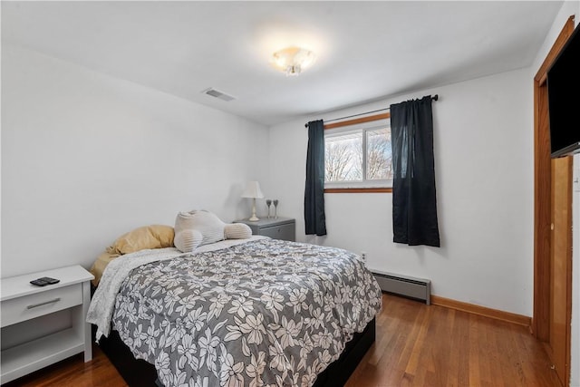 bedroom featuring a baseboard radiator and dark wood-type flooring