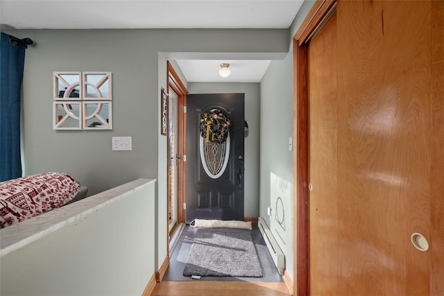 entryway with wood-type flooring and a baseboard heating unit