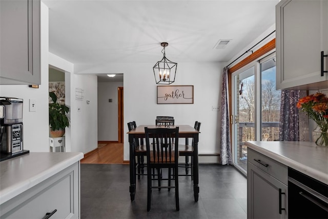 dining room with dark wood-type flooring, a baseboard radiator, and a chandelier