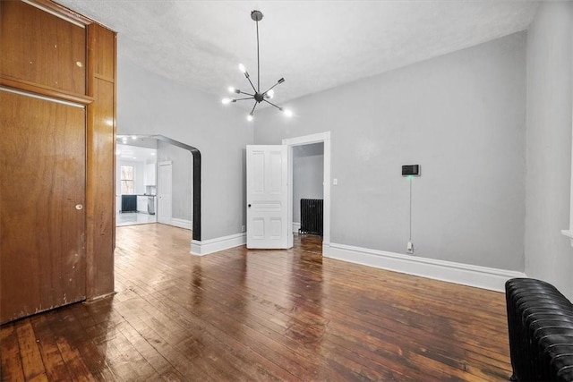 interior space featuring dark hardwood / wood-style flooring, a textured ceiling, and a chandelier