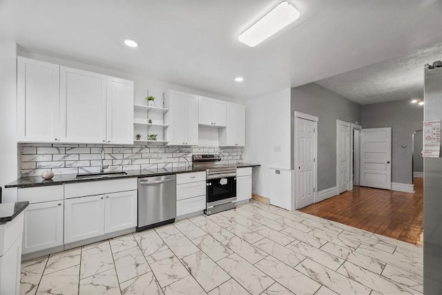 kitchen featuring white cabinets, sink, appliances with stainless steel finishes, tasteful backsplash, and light hardwood / wood-style floors