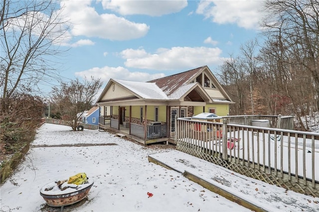 snow covered house with a wooden deck