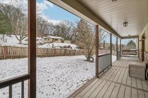 snow covered deck with a porch