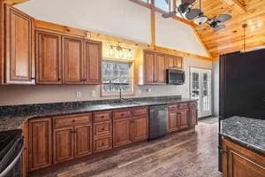 kitchen featuring ceiling fan, sink, vaulted ceiling with beams, dark hardwood / wood-style flooring, and stainless steel dishwasher