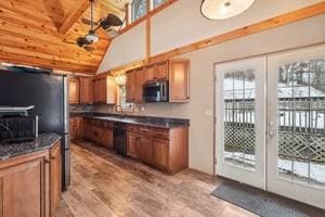 kitchen with vaulted ceiling with beams, french doors, stainless steel appliances, and light hardwood / wood-style flooring