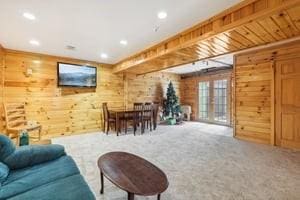 living room with carpet floors and wooden walls