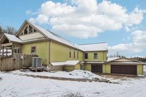 snow covered property featuring central AC