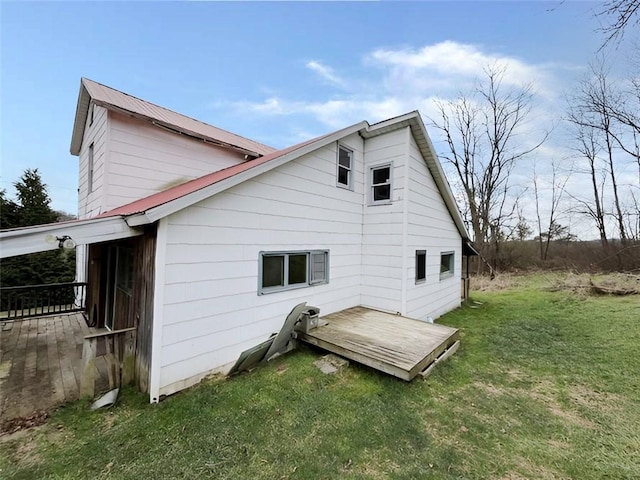 rear view of house with a deck and a yard