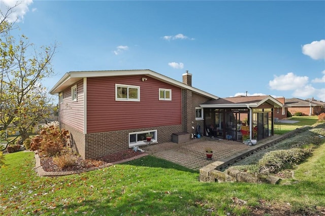 rear view of house featuring a sunroom, a yard, and a patio