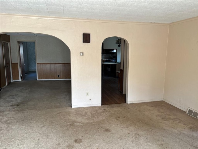 unfurnished room with dark colored carpet and a textured ceiling