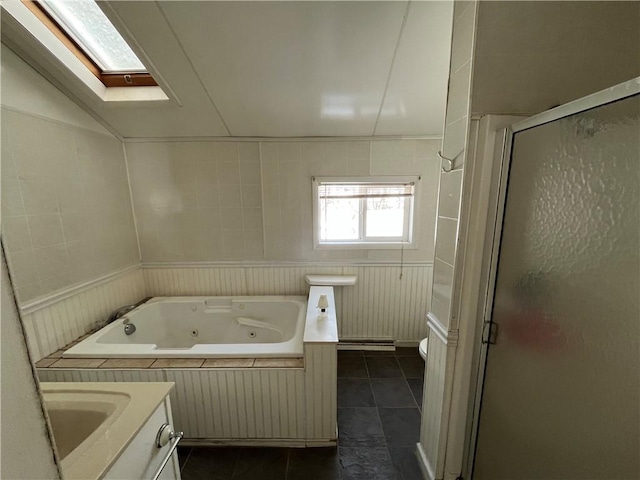 full bath featuring a shower stall, a jetted tub, tile patterned floors, toilet, and a skylight